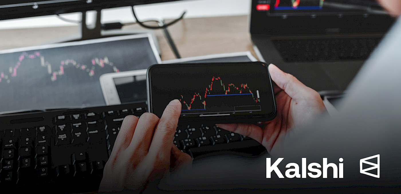 Hands hold a smartphone showing a market chart; Kalshi and Polymarket logos.